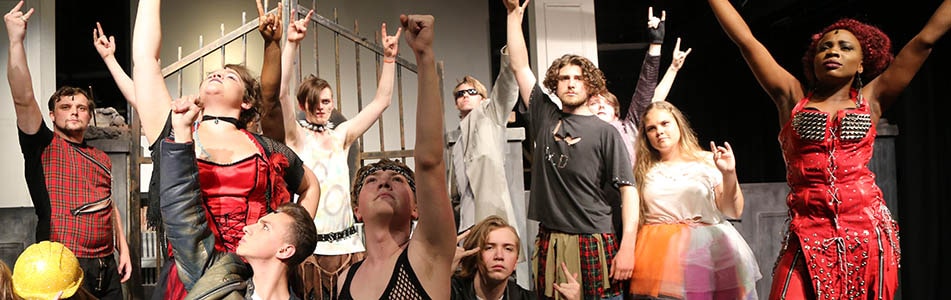 Students during a performance with their hands in the air